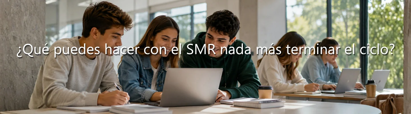Estudiantes del ciclo SMR trabajando con ordenadores en un aula moderna, representando las oportunidades laborales tras finalizar el Grado Medio en Sistemas Microinformáticos y Redes.