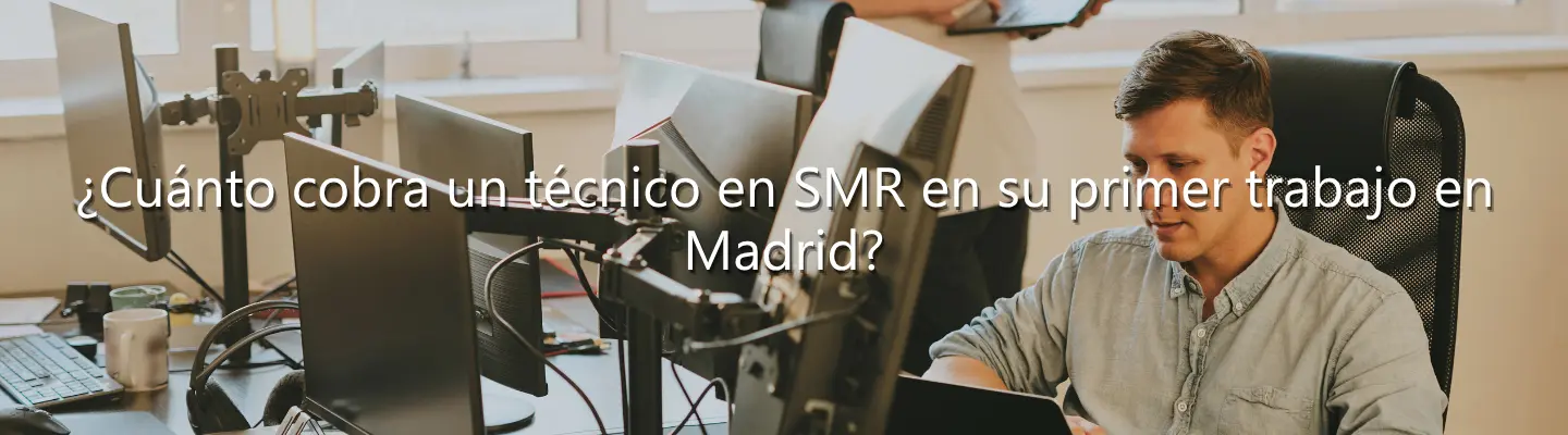 Técnico informático de SMR trabajando con varias pantallas en una oficina sobre sueldo inicial en Madrid.